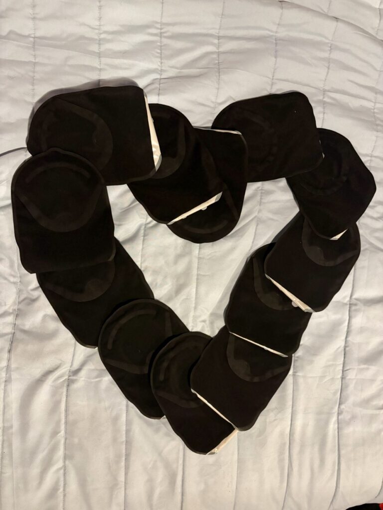A series of black ModaVi bags organised in the shape of a heart