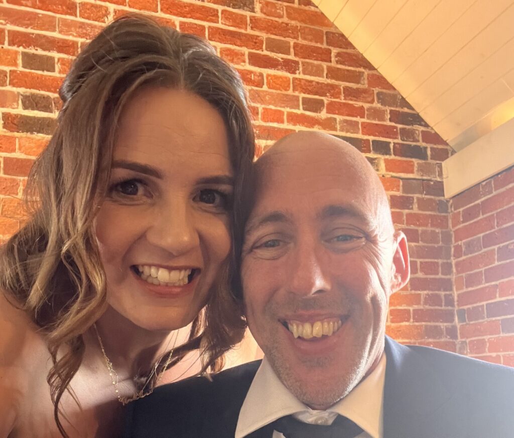 A man and a woman put their heads together and smile