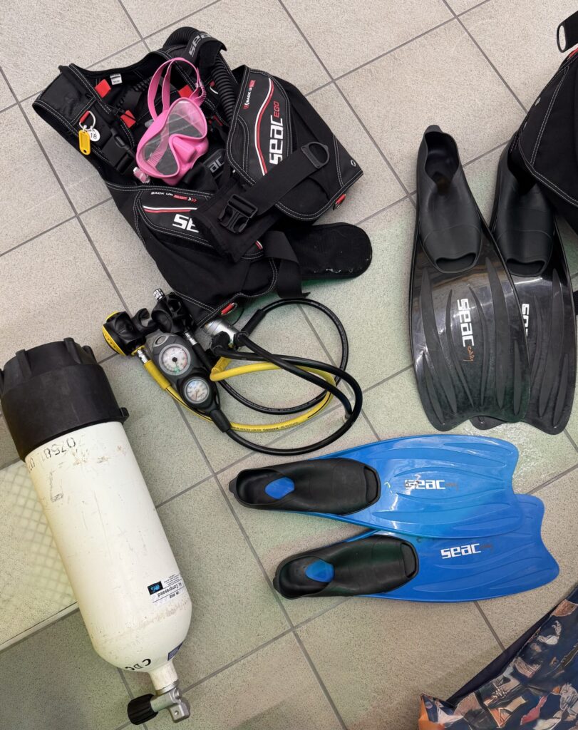 Scuba equipment laid out on the floor before a dive.