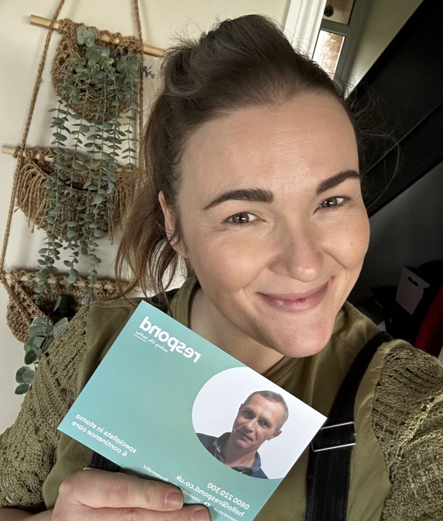 A woman smiles while holding a "Respond" card