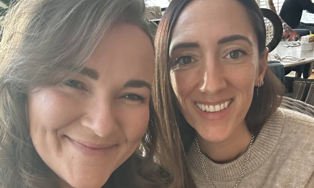 Two women smile at the camera